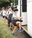 崩壊現場を迂回し、市街地側へ抜けた先でスクールバスに乗り込む児童たち＝出雲市大社町日御碕