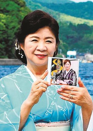 亡き長男への思いを込めた「隠岐の盆～シャーラ船～」などを収録したＤＶＤを手にする西脇恵子さん＝島根県西ノ島町別府