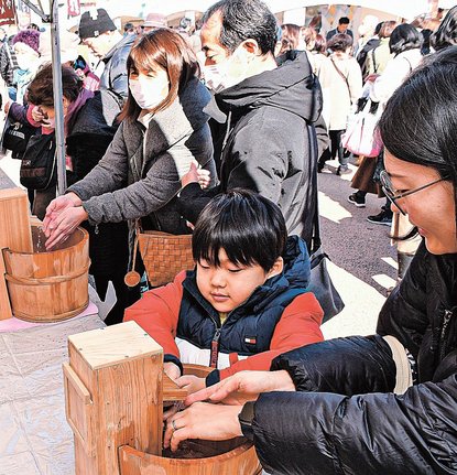 美又温泉の湯に触れる来場者＝広島市中区、ひろしまゲートパーク