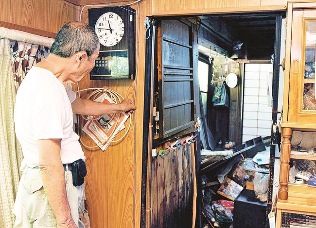 裏山が崩れ、土砂が部屋にまで押し寄せ、立ち尽くす住民＝雲南市掛合町多根