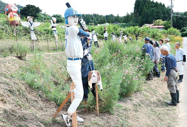 棚田前に設置された大谷翔平選手らを模したかかしを見る住民＝浜田市三隅町室谷