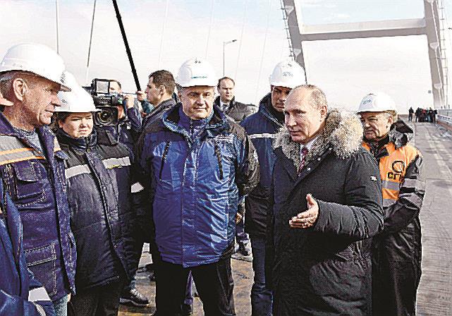 ２０１８年３月、ロシアが併合したウクライナ南部クリミア半島で、ロシア本土と直結させる橋を視察するプーチン大統領（右から２人目）（ロシア大統領府提供、ロイター＝共同）