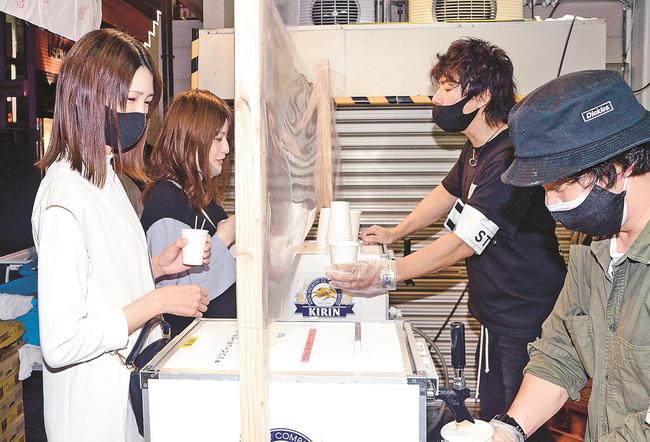 生ビールをふるまう実行委員のメンバー（右）＝松江市伊勢宮町