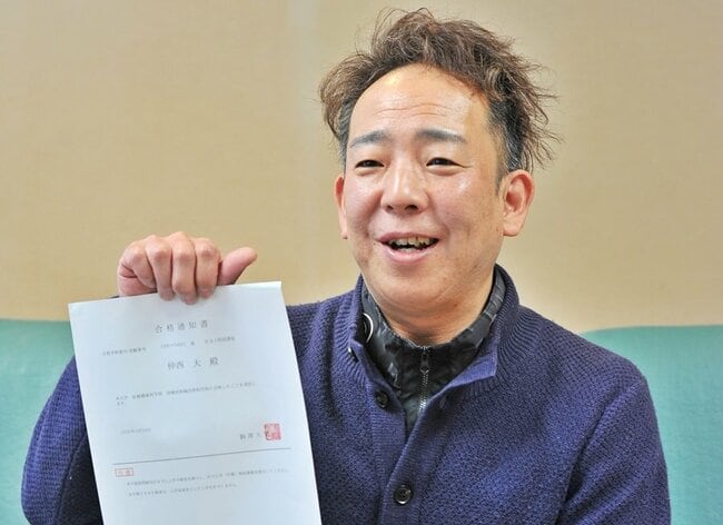 駒沢大の合格通知書を手にする仲西大さん＝松江市東出雲町錦浜、コウダイ