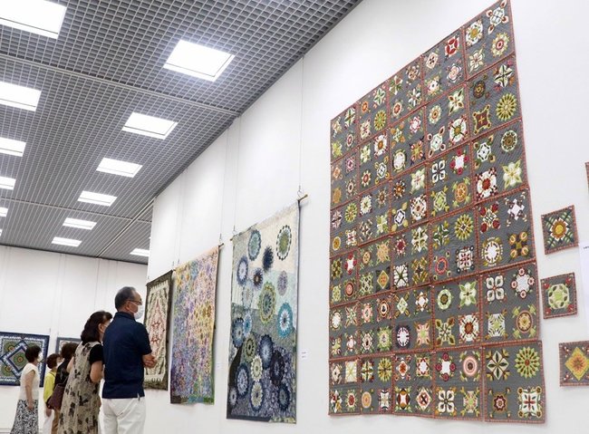 パッチワークキルトの大作に見入る来館者＝松江市袖師町、島根県立美術館