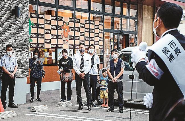 市長選立候補者（右）の演説に耳を傾ける市民＝浜田市内
