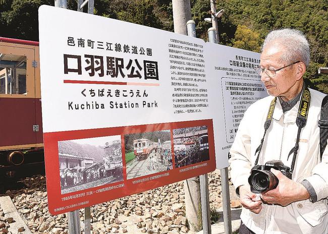 三江線鉄道公園の看板に使用された自身の写真を見つめ、当時を振り返る三上茂さん