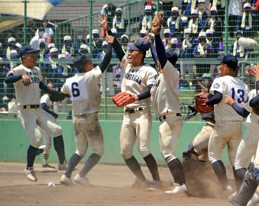 優勝を決め、ノーヒットノーランを達成した山崎琢磨投手（左から３人目）に駆け寄って喜ぶ石見智翠館ナイン＝県立浜山球場