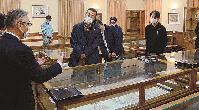 仲野義文館長（左）の解説を聞く会員＝大田市大森町、なかむら館