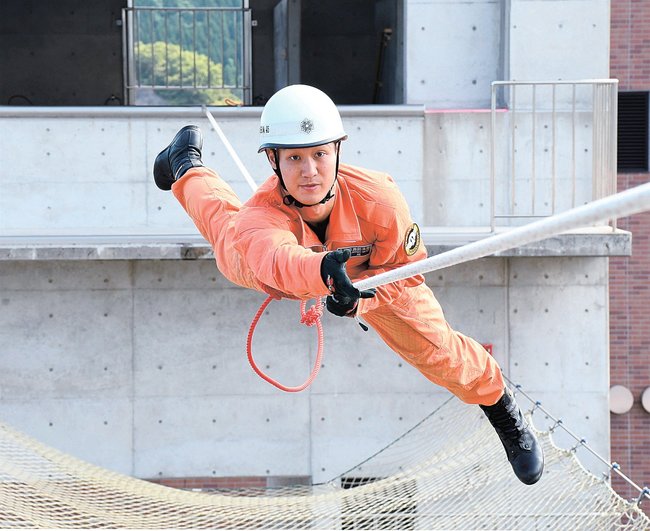 全国大会に向けてロープブリッジ渡過の訓練をする生越智昭さん=大田市大田町、大田消防署