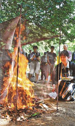 故人に充てた手紙を炎に投げ入れる参加者=松江市東出雲町揖屋、黄泉比良坂