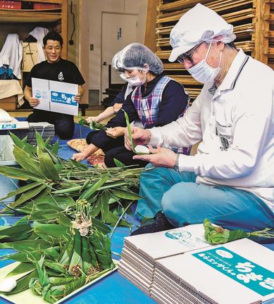 ササの下準備や試し巻きする住民たち＝安来市広瀬町西比田、旧ＪＡ比田マーケット