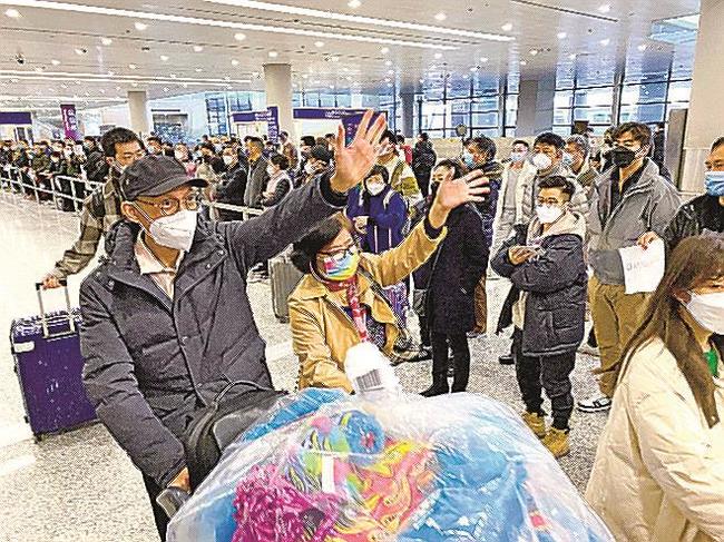 中国の上海浦東国際空港に到着し手を振る人たち＝８日（共同）