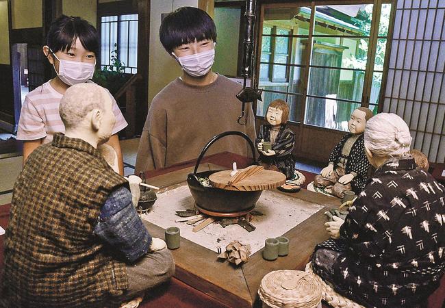 表情豊かな作品に見入る来場者＝鳥取県智頭町智頭