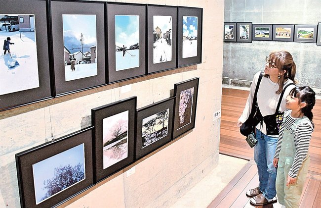 「組写真」に見入る来場者＝雲南市木次町寺領、ワイナリー奥出雲葡萄園地下ギャラリー
