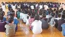 集会で体育館の床に「体育座り」する子どもたち（資料）
