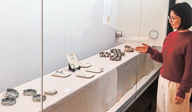 新春の訪れを感じる作品を紹介する藤井美保学芸員=松江市北堀町、田部美術館