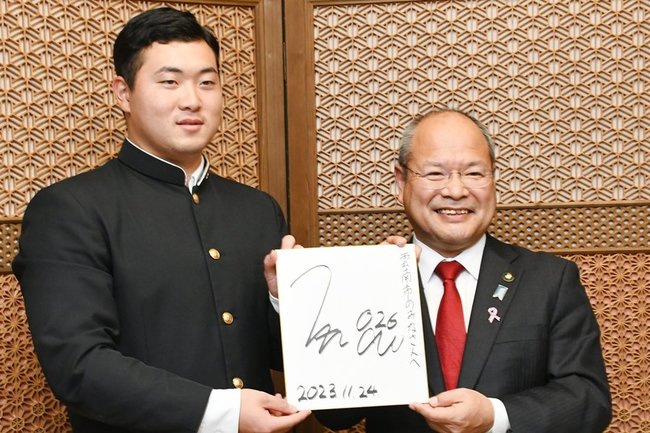 石飛厚志市長（右）にサインを贈り、活躍を誓う高野颯太選手＝雲南市木次町里方、市役所
