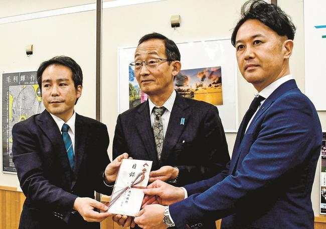 寄贈図書の目録を受け取る鳥取県教育委員会の足羽英樹教育長（中央）＝鳥取市東町１丁目、県庁
