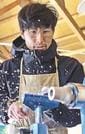 機械で木材を削り出す沖原昌樹さん＝浜田市弥栄町長安本郷