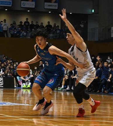 昨年の覇者・琉球ゴールデンキングス相手にドリブルで攻め込む島根スサノオマジックの安藤誓哉選手（左）＝４月14日、松江市総合体育館
