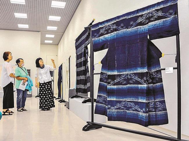 緻密な文様が浮かぶ出雲織を鑑賞する来館者ら＝松江市袖師町、島根県立美術館