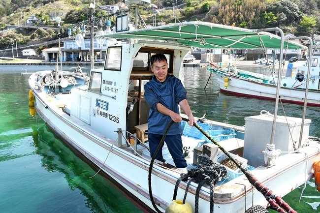 昨年夏に購入した船の上で作業する坂本洋一さん=出雲市塩津町