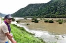 増水した江の川を眺める住民＝１５日午前１０時４分、江津市松川町