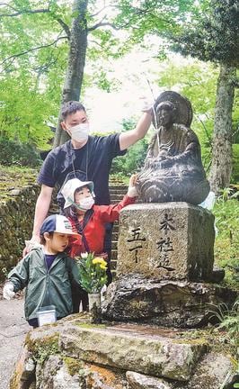 地蔵菩薩を磨く参加者たち＝鳥取県大山町大山、大山寺参道