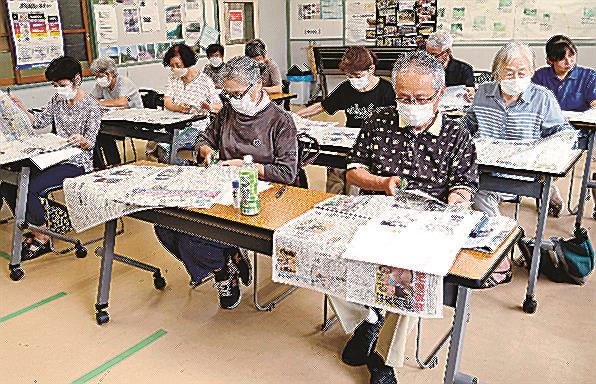 新聞を広げ、気になった記事をスクラップする参加者＝島根県美郷町九日市、沢谷公民館