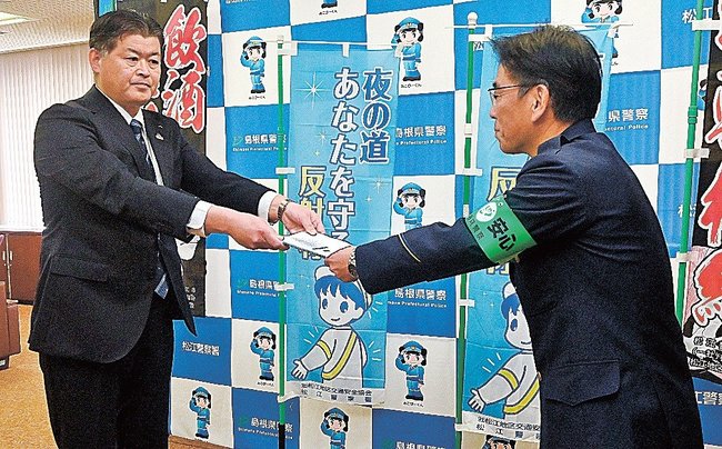 署名簿を提出する越野浩昭本部長(左)=松江市袖師町、松江署