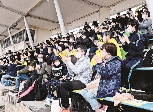 前半１分に松江シティＦＣが先制し、手をたたいて喜ぶサポーター＝松江市上乃木１０丁目、市営陸上競技場