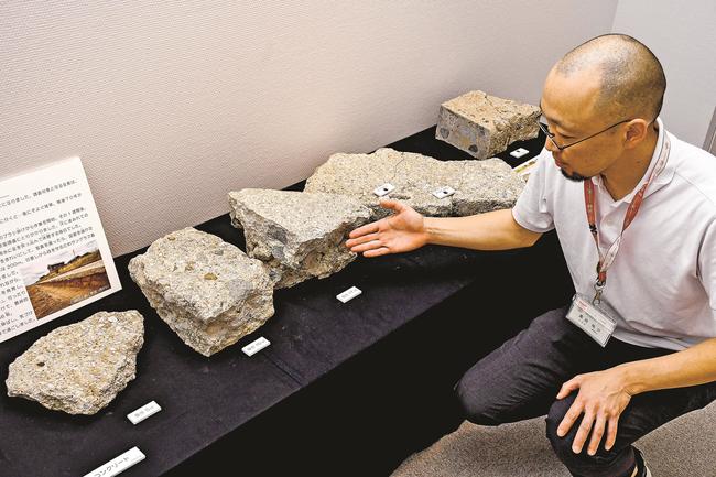 旧海軍大社基地滑走路に使われていたコンクリート片を説明する黒田祐介学芸員＝出雲市大津町、出雲弥生の森博物館