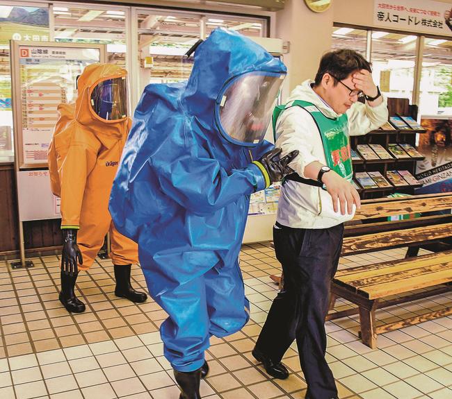 テロを想定した訓練で、有毒ガスによる体調不良者を救助する消防隊員＝大田市大田町、ＪＲ大田市駅
