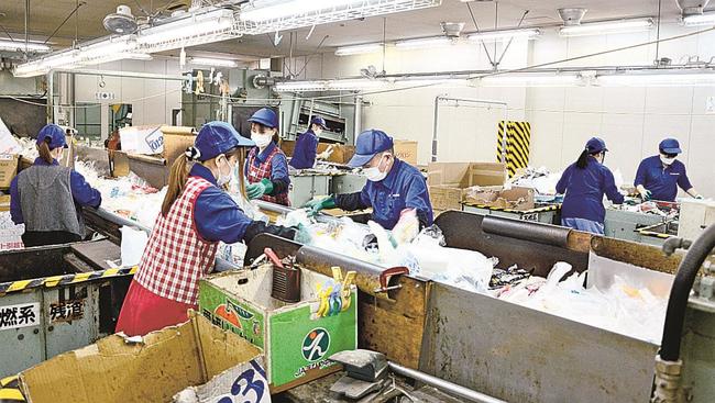 資源ごみを選別する作業員＝松江市竹矢町、川向リサイクルプラザ