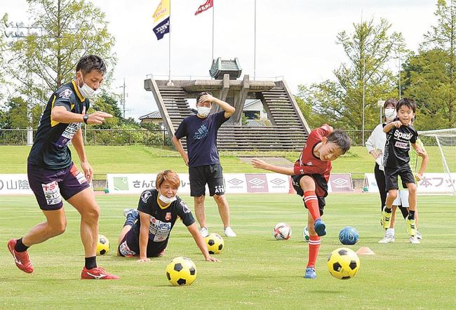 松江シティＦＣの選手とシュート対決をする参加者＝松江市上乃木１０丁目、市営陸上競技場