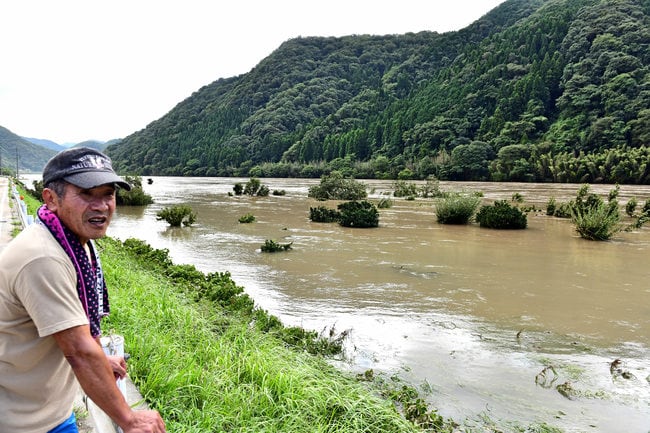 増水した江の川を眺める住民＝１５日午前１０時４分、江津市松川町