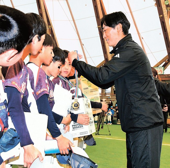 選手にメダルをかける和田毅さん(右)=出雲市矢野町、出雲ドーム