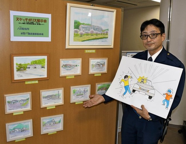 自作の紙芝居を手に雲南署などを描いた作品を紹介する木村一博巡査部長＝雲南市三刀屋町三刀屋、雲南署