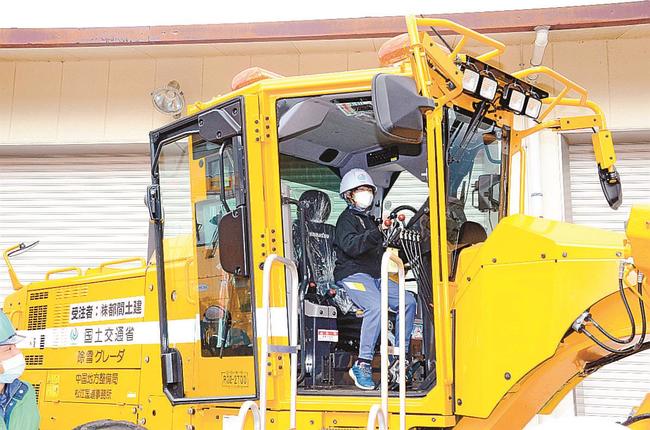 除雪グレーダの運転席に乗る児童＝島根県飯南町頓原
