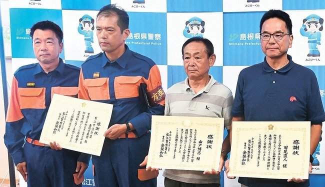 感謝状を手にする高井博邦団長(左から2人目)、山戸博志さん(同3人目)、田尾直人さん(右端)=松江市袖師町、松江署