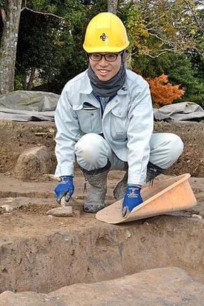 「文字のない時代の生活や文化をひも解けるのが考古学の魅力」と話す吉松優希さん＝松江市大草町、出雲国府跡