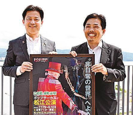 ポップサーカス松江公演のポスターを手にする上定昭仁市長（左）と久保田悟社長＝松江市末次町、市役所