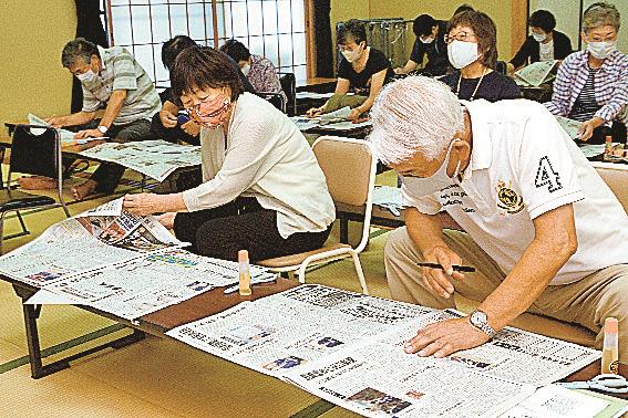 新聞に目を通し、気になる記事を探す参加者＝松江市比津町、法吉公民館