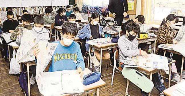 山陰中央新報に目を通す児童＝出雲市斐川町直江、市立中部小学校