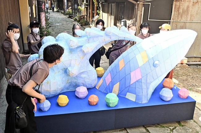 くじらをモチーフにしたあんどんを、青石畳通りに設置する京都芸術大の学生たち＝松江市美保関町美保関