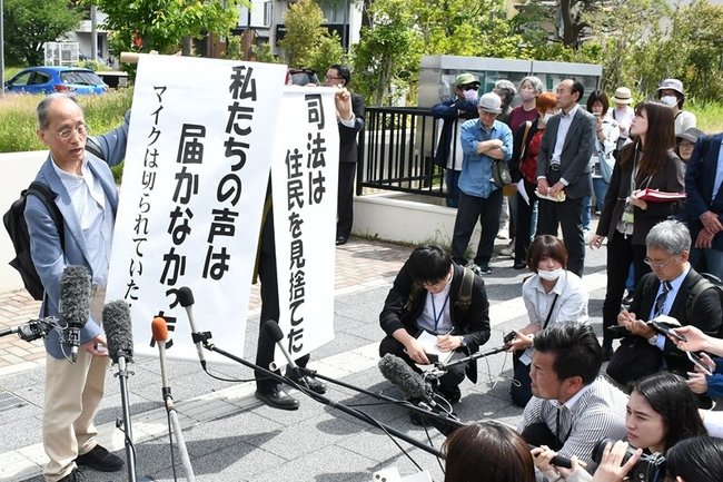 島根原発２号機差し止め仮処分を却下する決定を受け、「司法は住民を見捨てた」などと掲げる住民側＝１５日午前１０時５分、松江市母衣町、広島高裁松江支部