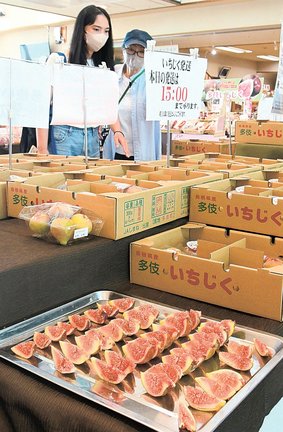採れたてのイチジクの品定めをする来場者＝出雲市多伎町多岐、道の駅キララ多伎