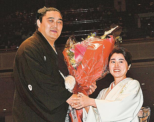 断髪後、詩子夫人から花束を受け取る