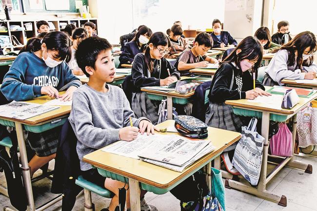 新聞記事に目を通し、見出しやリードの役割を確認する児童=松江市大庭町、大庭小学校